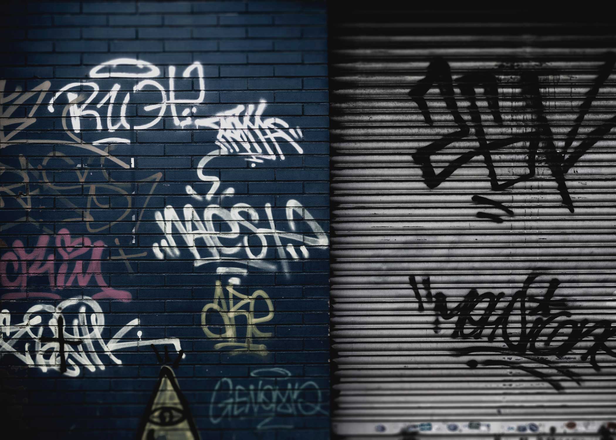 brick wall and steel door with graffiti