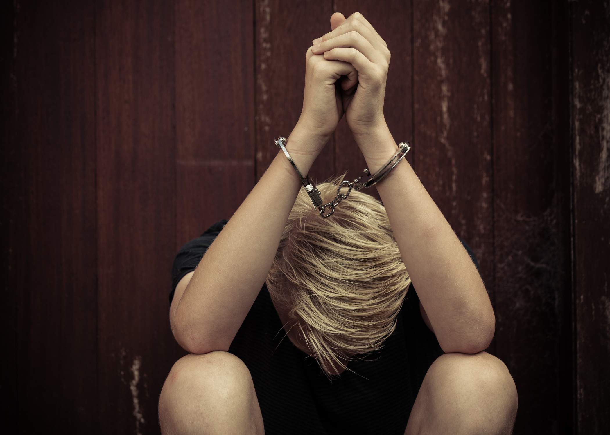 Boy-sitting-in-handcuffs